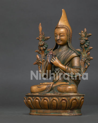 Tsongkhapa statue side view showing wisdom sword sacred scripture and blooming lotus stems.