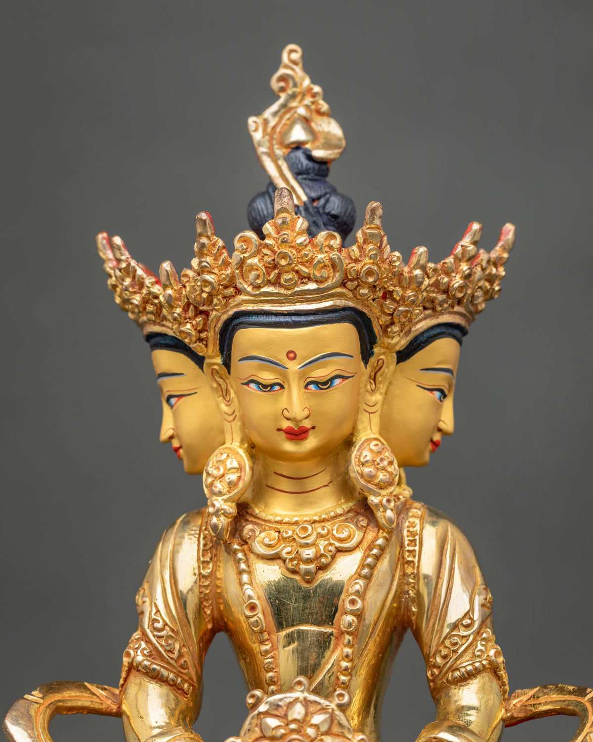 Vairocana Buddha Statue face close up four serene faces 24K gold painted details.