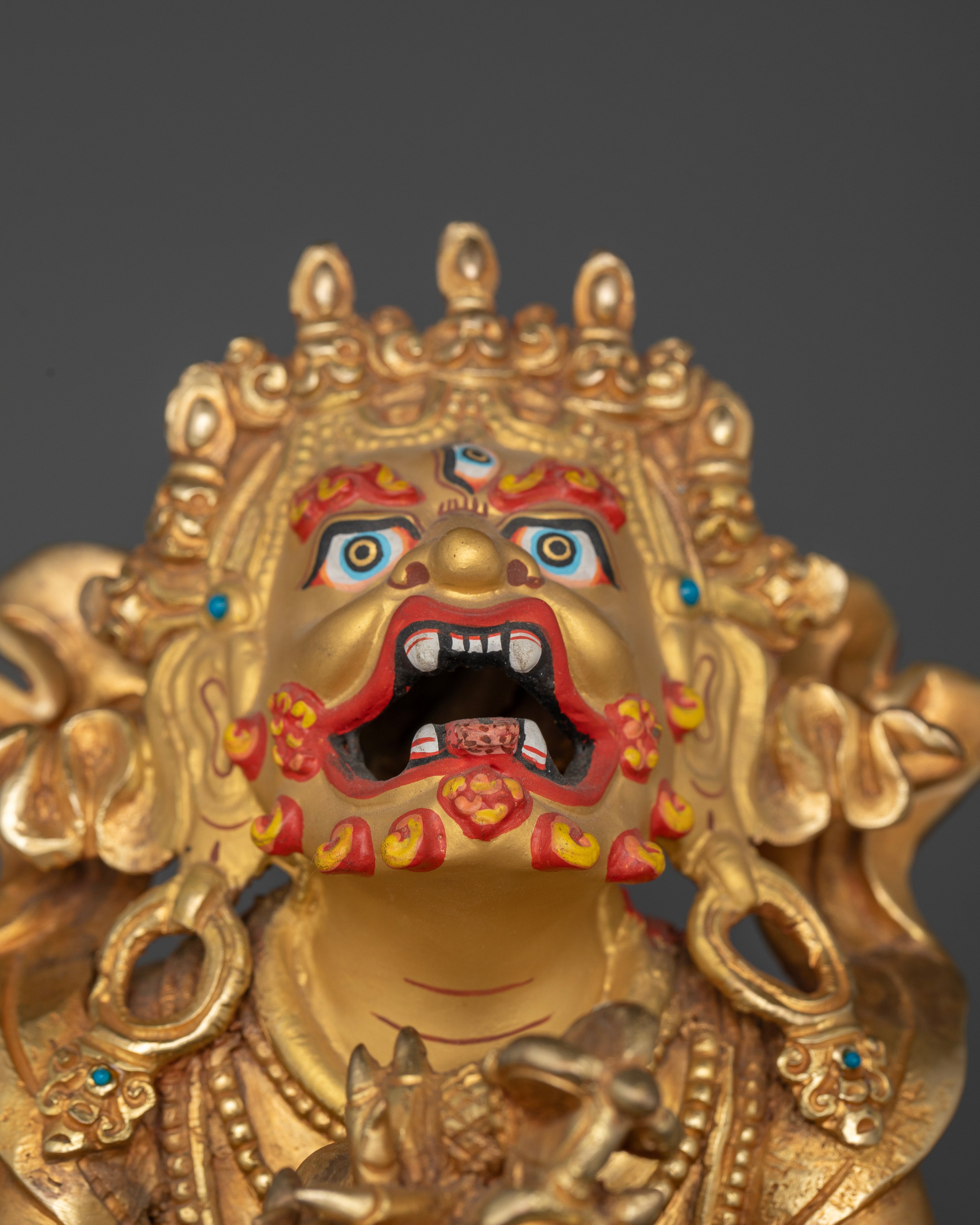 Vajradhaka Buddhist statue with gold painted face and stone adornments.