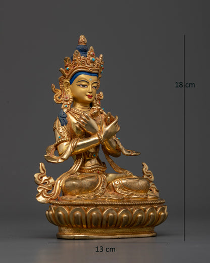 Vajradhara Buddha seated on a lotus pedestal holding a vajra and bell with arms crossed at the heart