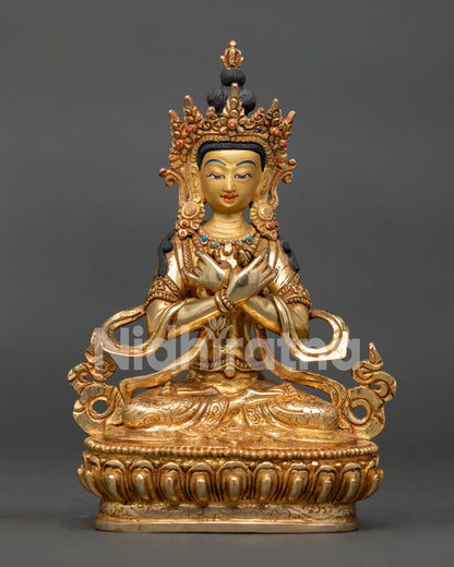 Vajradhara Buddhist deity statue seated in vajraparyanka posture holding vajra and bell on lotus pedestal.
