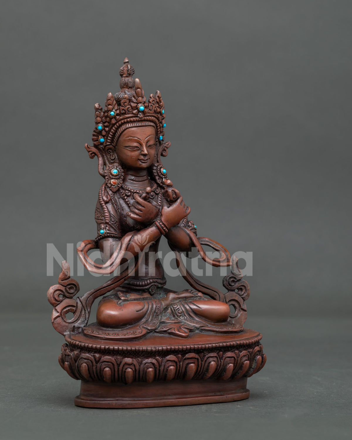 Vajradhara holding vajra and bell with semi precious stone ornamentation.