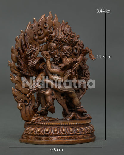 Vajrakilaya statue depicting the deity standing with consort on an ornate lotus pedestal, accompanied by a human figure.