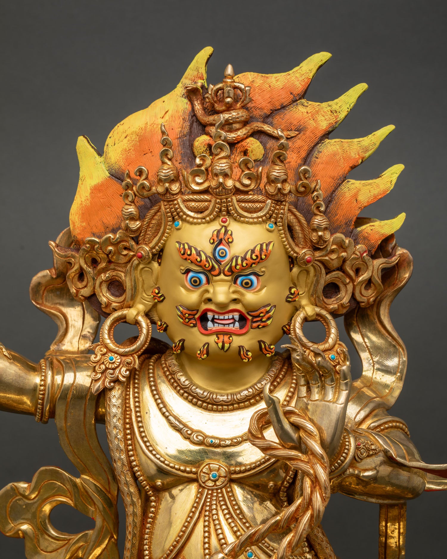 Vajrapani close up radiant 24K gold face turquoise coral stones wrathful deity sculpture