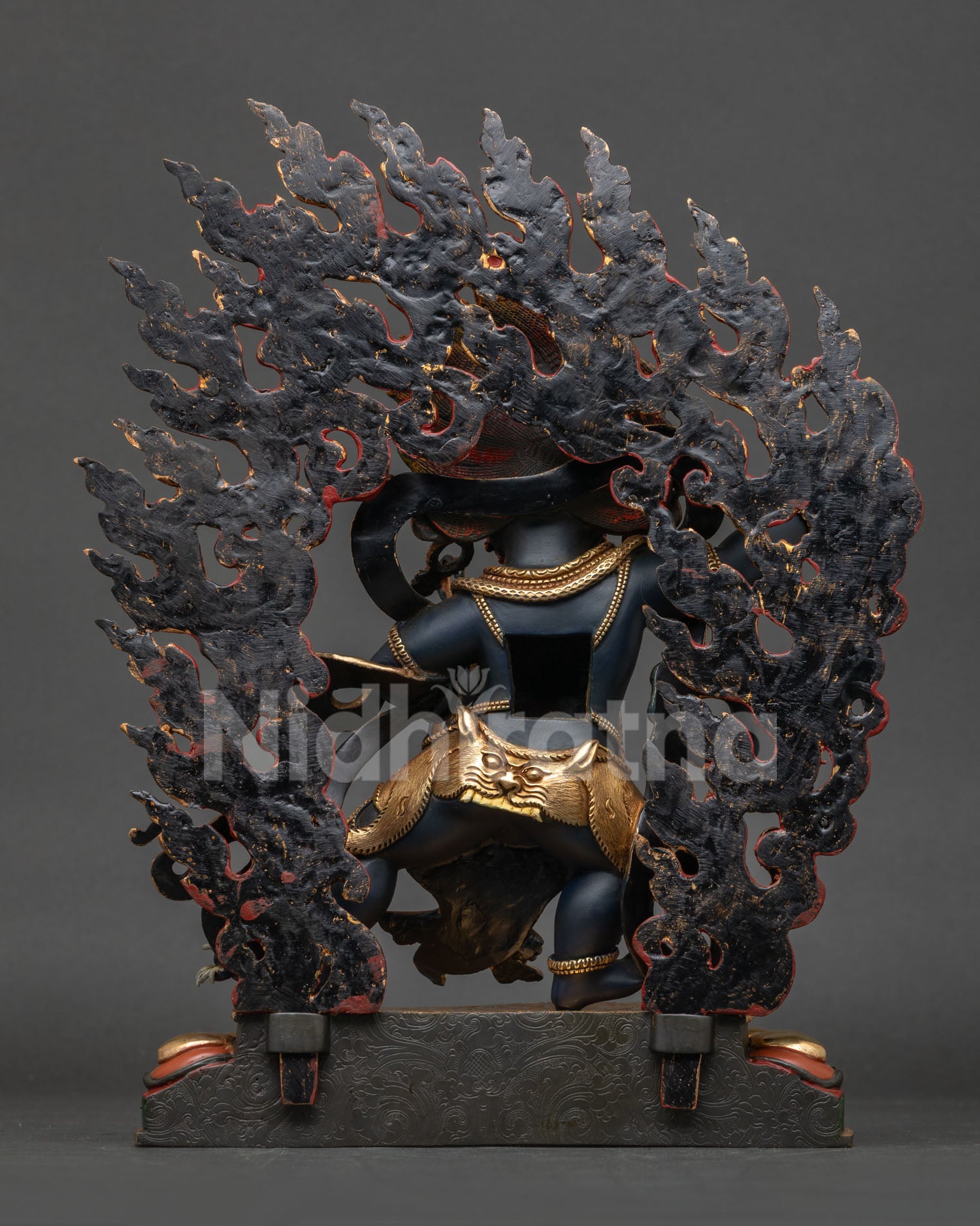Vajrapani statue back view showing flowing patterned robe intricate handcrafted details.