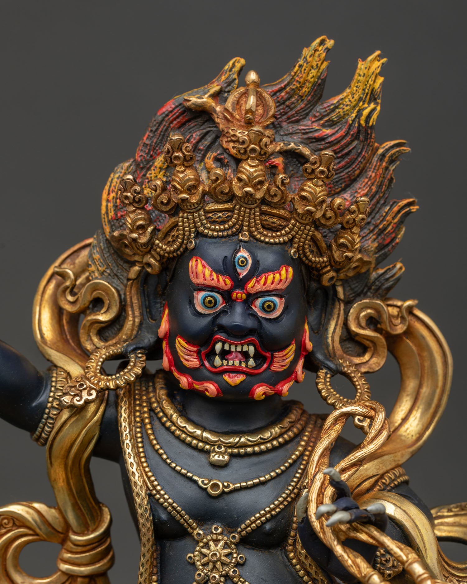 Vajrapani statue front closeup showing wrathful expression skull crown and ornate details.