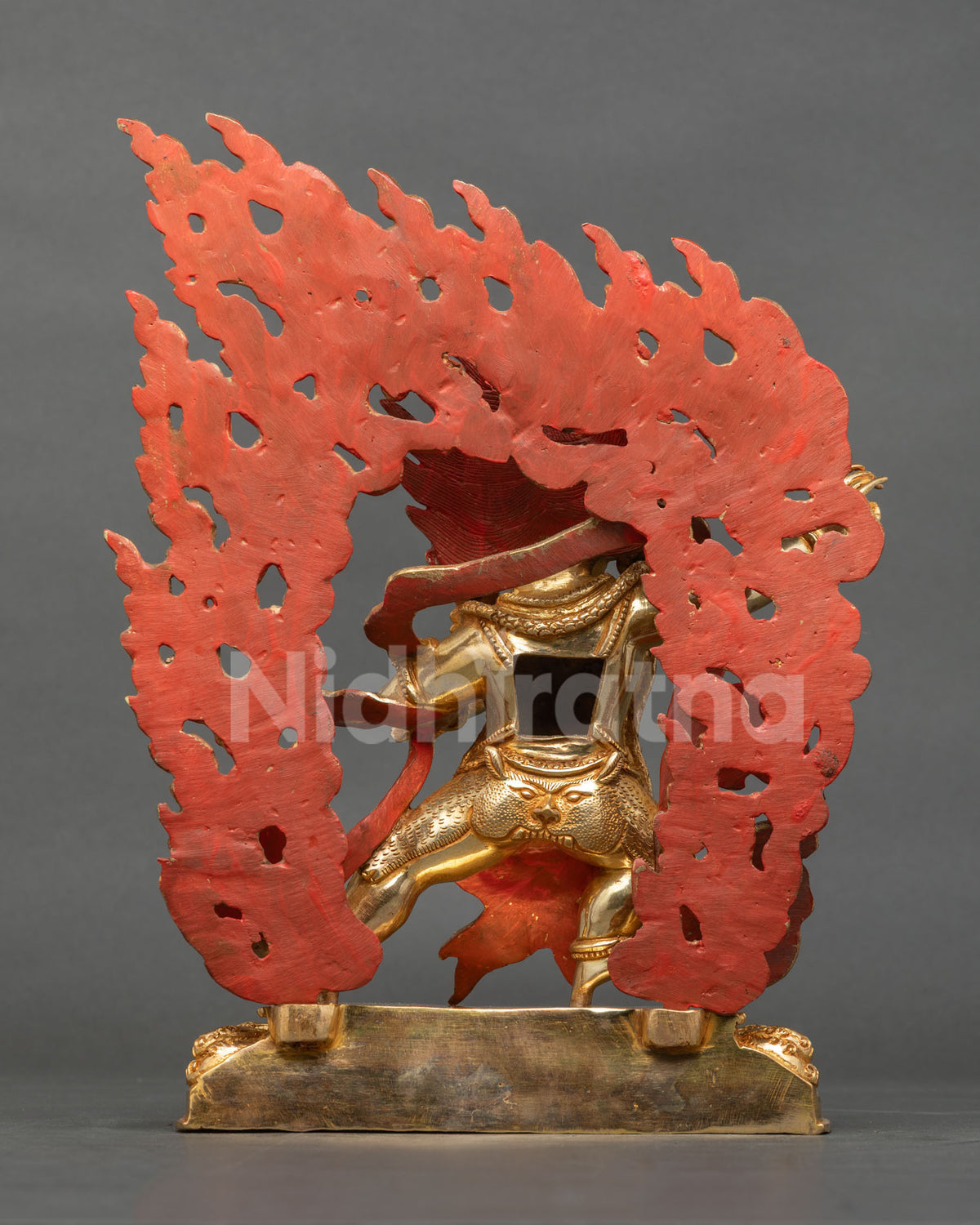 Vajrapani statue in warrior posture on lotus seat with blazing halo.