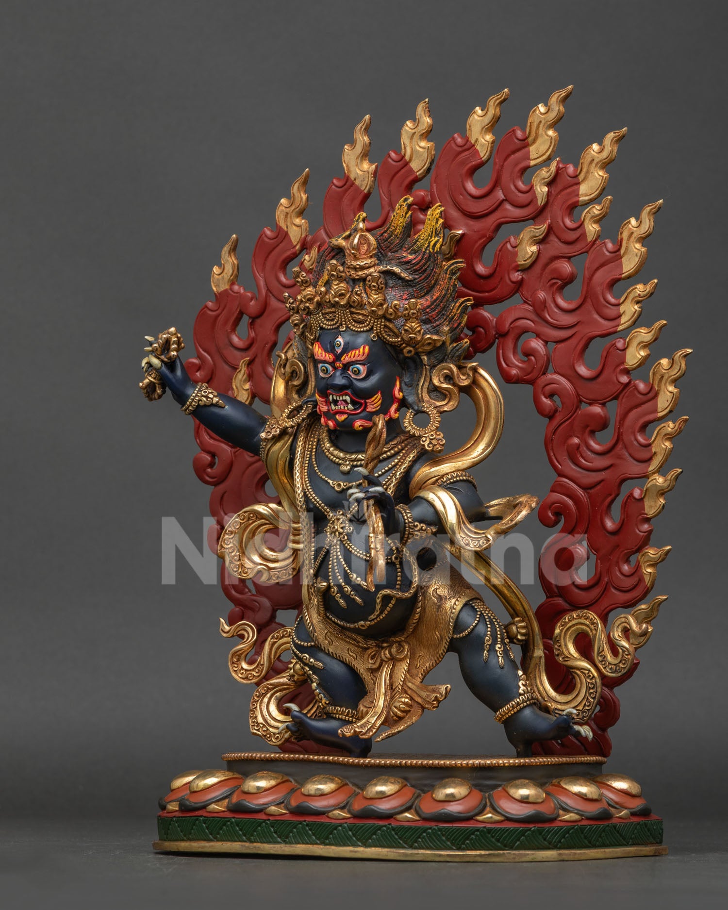 Vajrapani statue left view showing skull crown flaming hair and blazing halo.