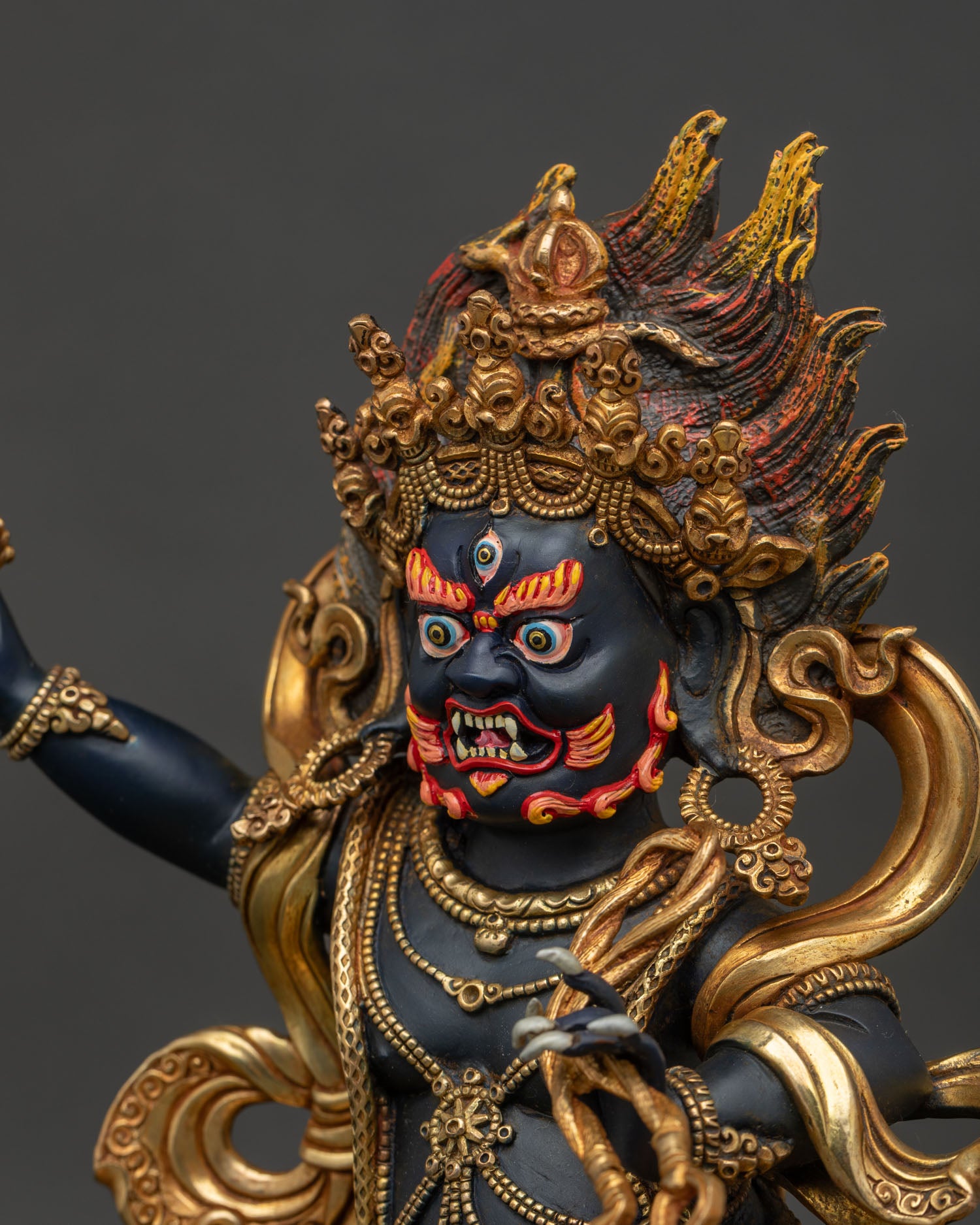 Vajrapani statue side face closeup showing fierce expression flaming hair and skull crown.