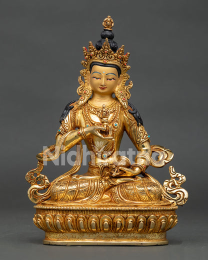 Vajrasattva Buddha statue holding five pronged vajra and bell on lotus pedestal.