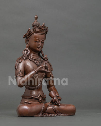 Vajrasattva buddhist statue holding five pronged vajra and bell.