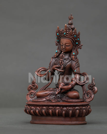 Vajrasattva Buddhist statue seated in meditation with five pronged vajra and ritual bell.