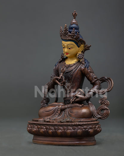 Vajrasattva Buddhist statue seated on lotus pedestal holding vajra and bell with traditional details.