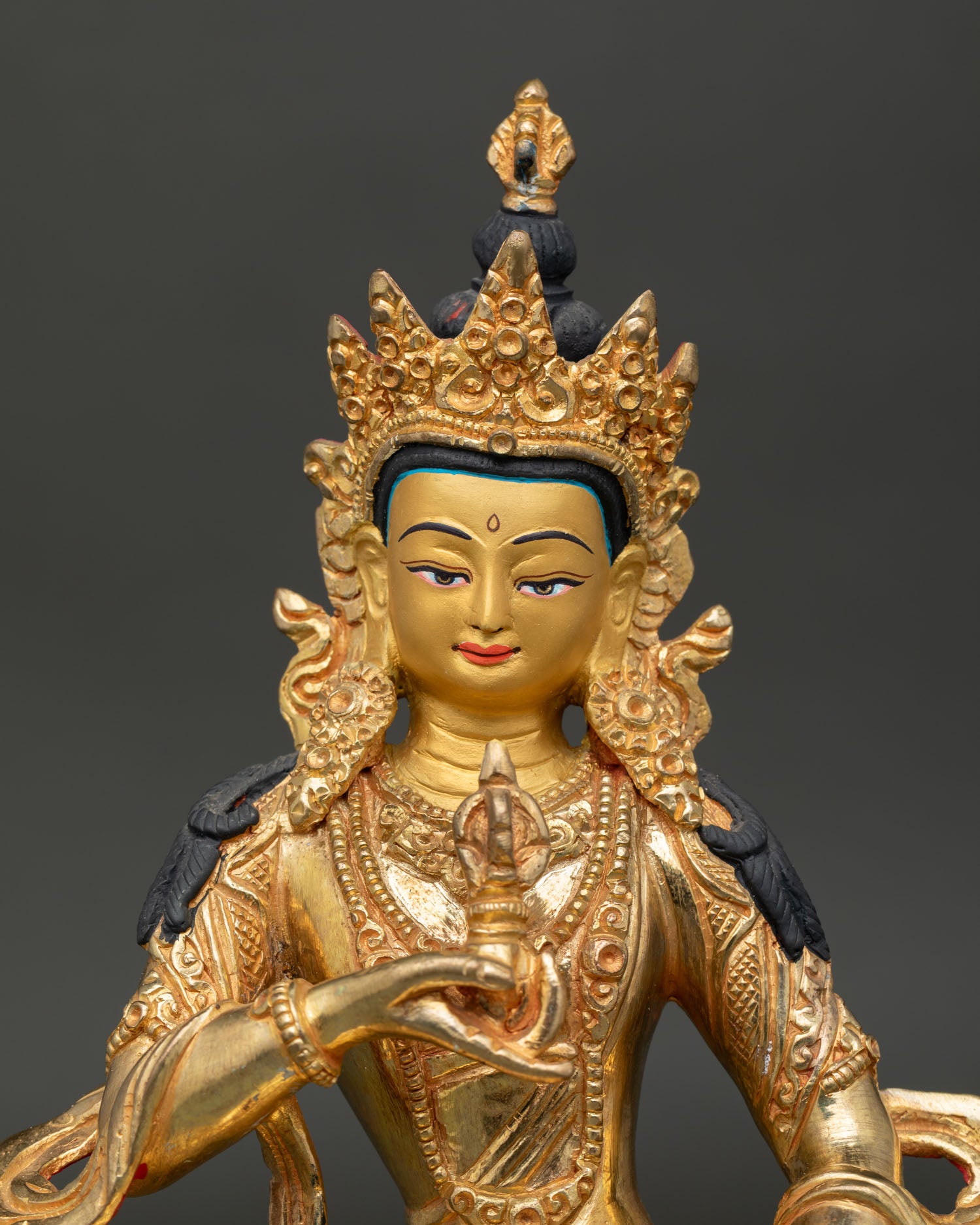 Vajrasattva face showing gold painted details and serene meditation expression.