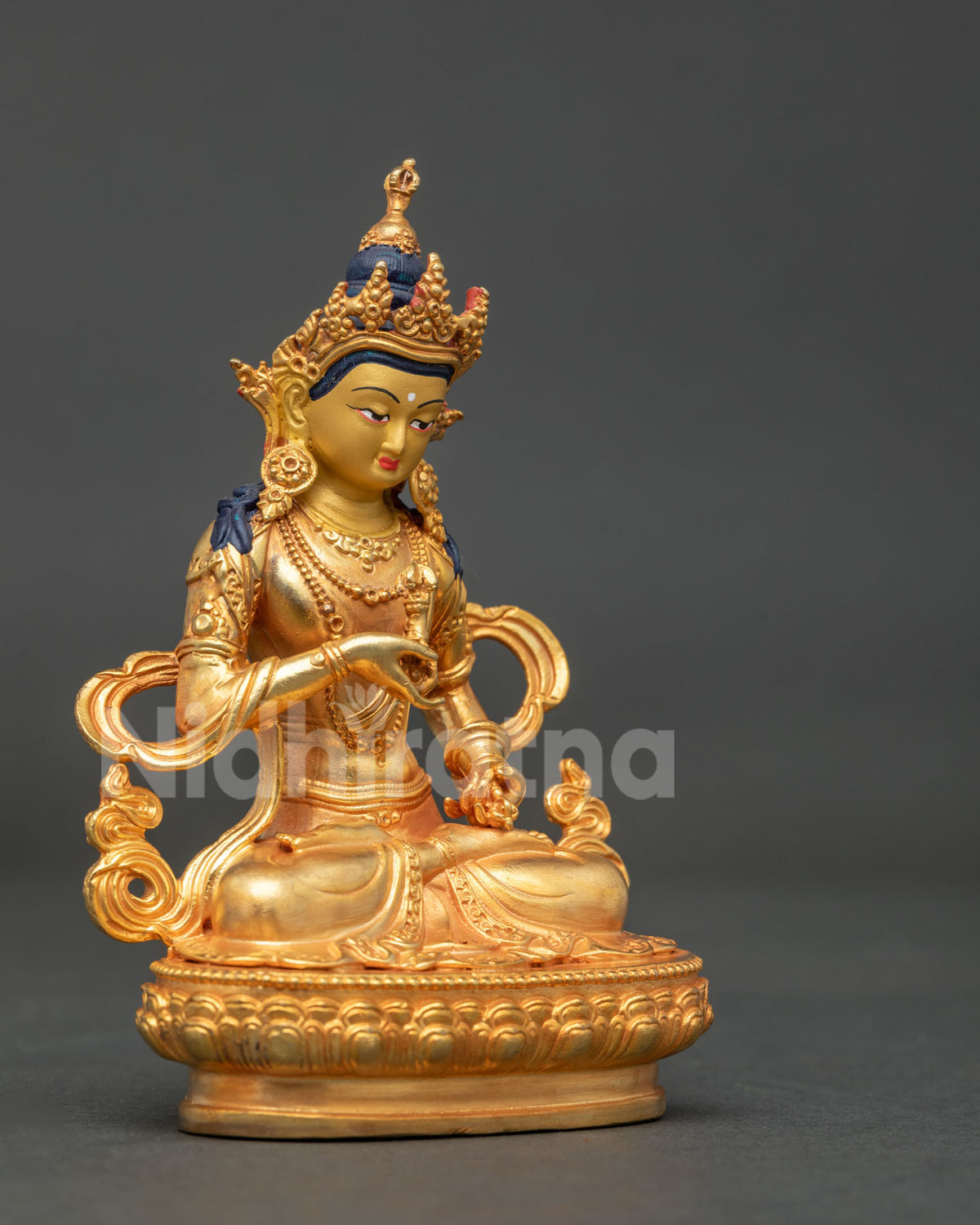 Vajrasattva seated on hand carved lotus pedestal holding vajra and bell in traditional posture.