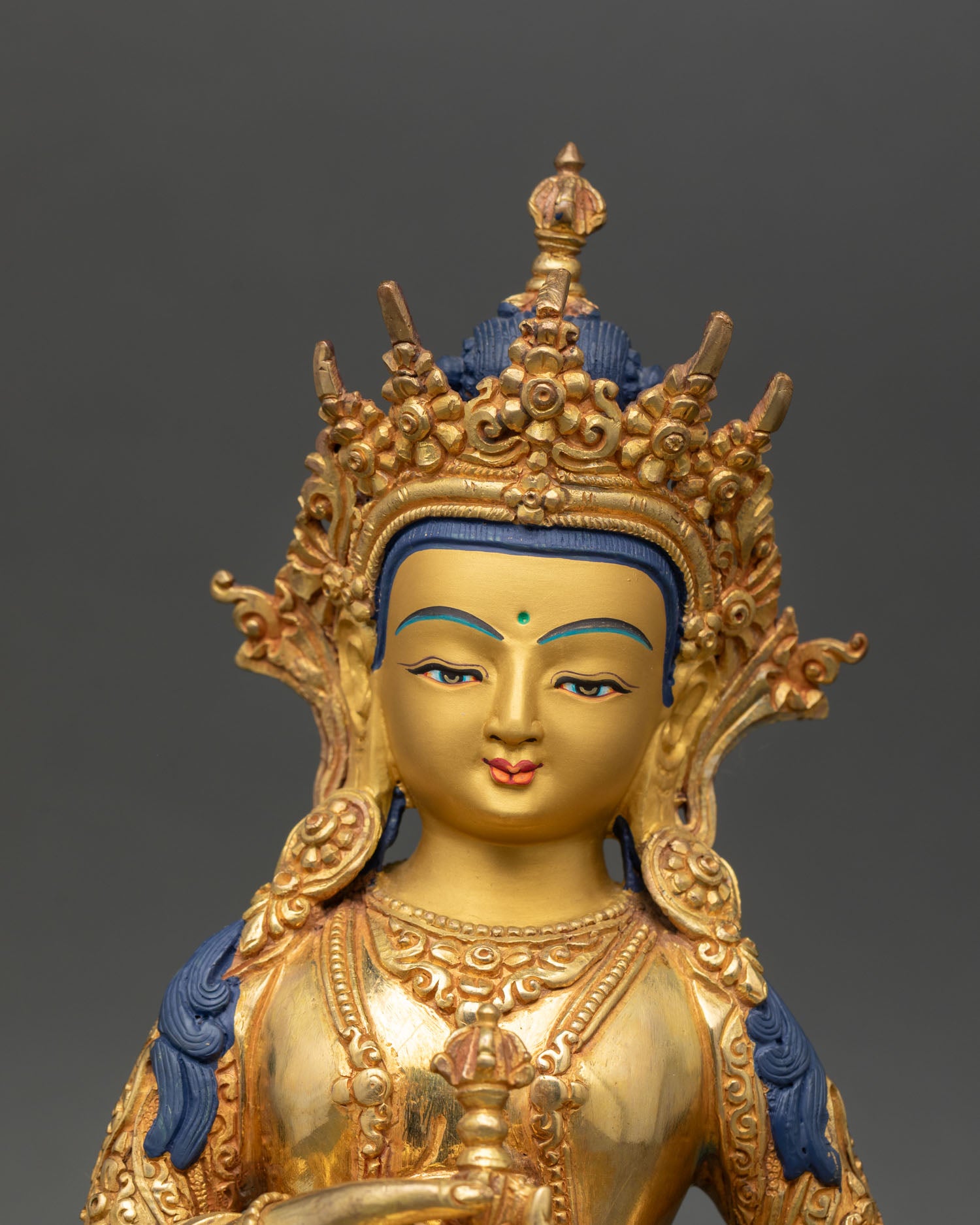 Vajrasattva statue close up gold painted face ornate crown semi precious stones detail