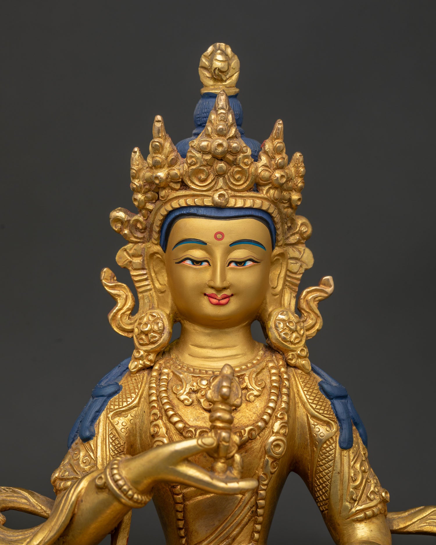 Vajrasattva Statue close up showing gold painted face five jewel crown and vajra