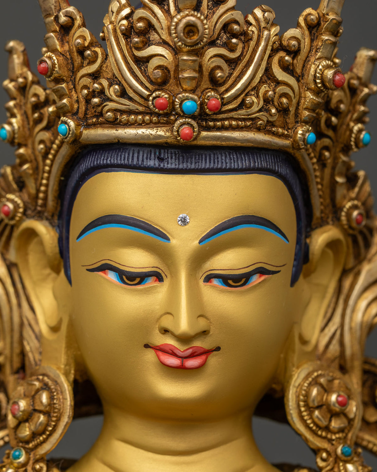 Vajrasattva statue face close up, hand-painted gold features and Five-Jeweled Crown