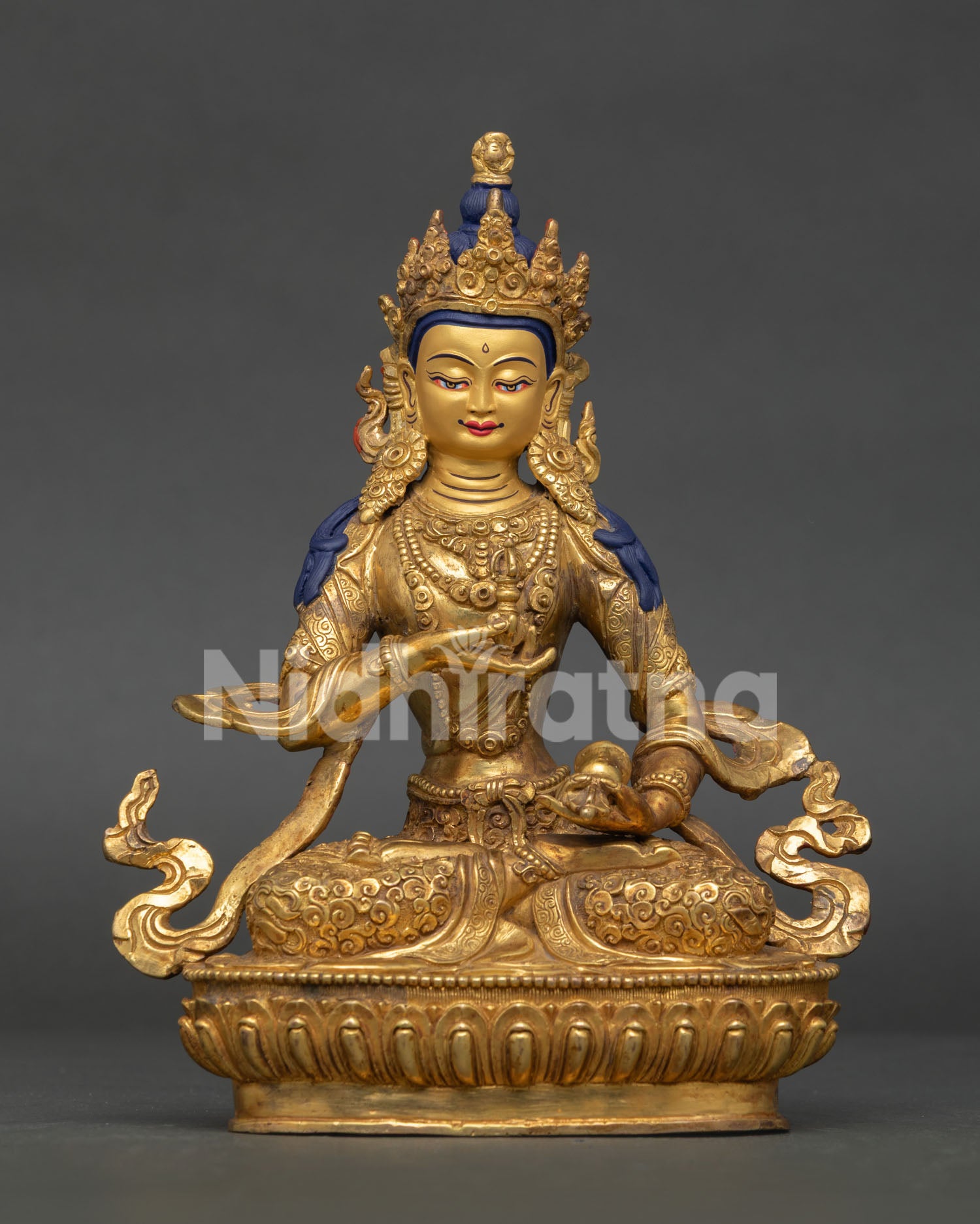 Vajrasattva statue holding five pronged vajra and ritual bell in vajraparyanka posture.