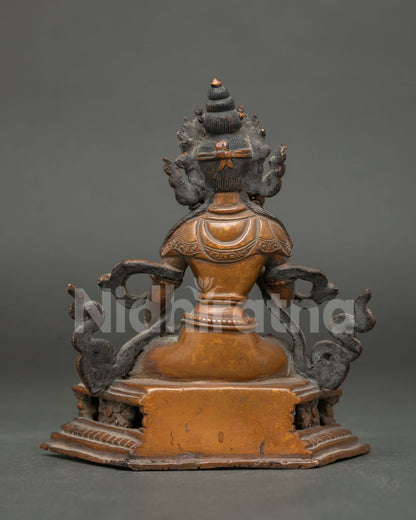 Vajrasattva statue seated on ornate throne chemically oxidized copper back view.