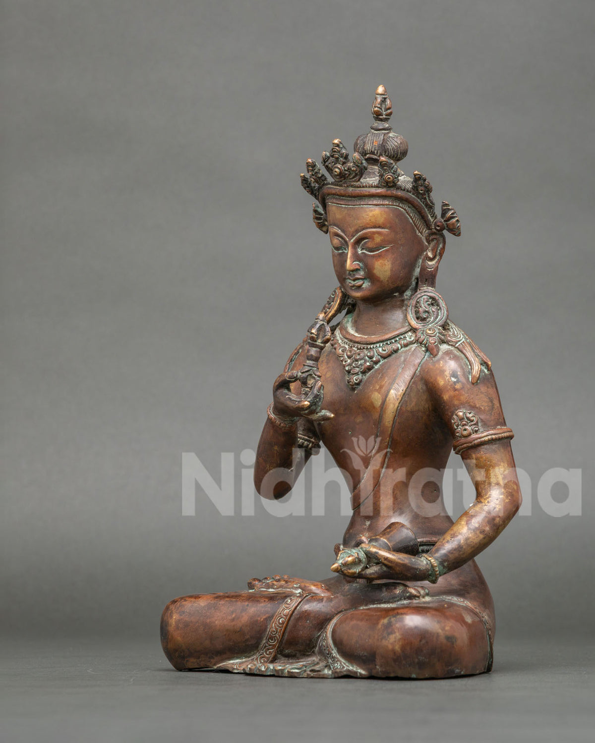 Vajrasattva statue side view layered necklaces and finely chased ornaments.