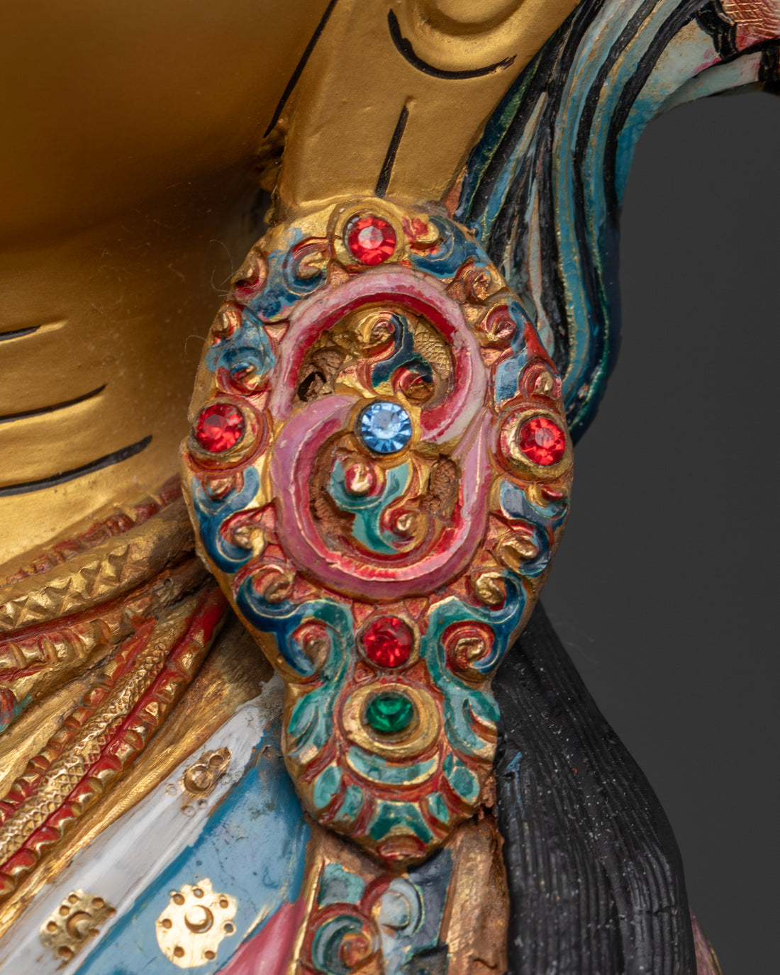 earring of vajrasattva statue adorned with ruby and emerald gemstones