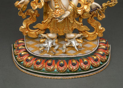 White Mahakala standing upon two white elephants on a sun disc above a richly painted lotus seat