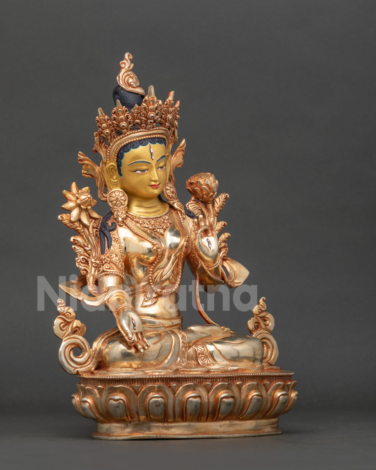 White Tara Buddhist statue with seven eyes jeweled crown silk garment and intricate hand chased copper details.