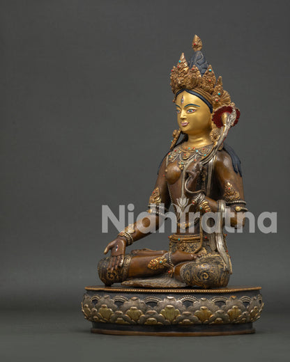 White tara holding blooming lotus with gold gilded details and serene expression.