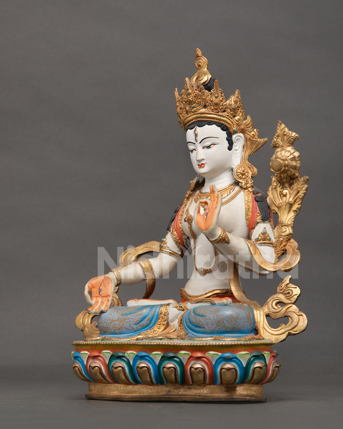 White Tara statue seated on a hand carved multicolor lotus pedestal.