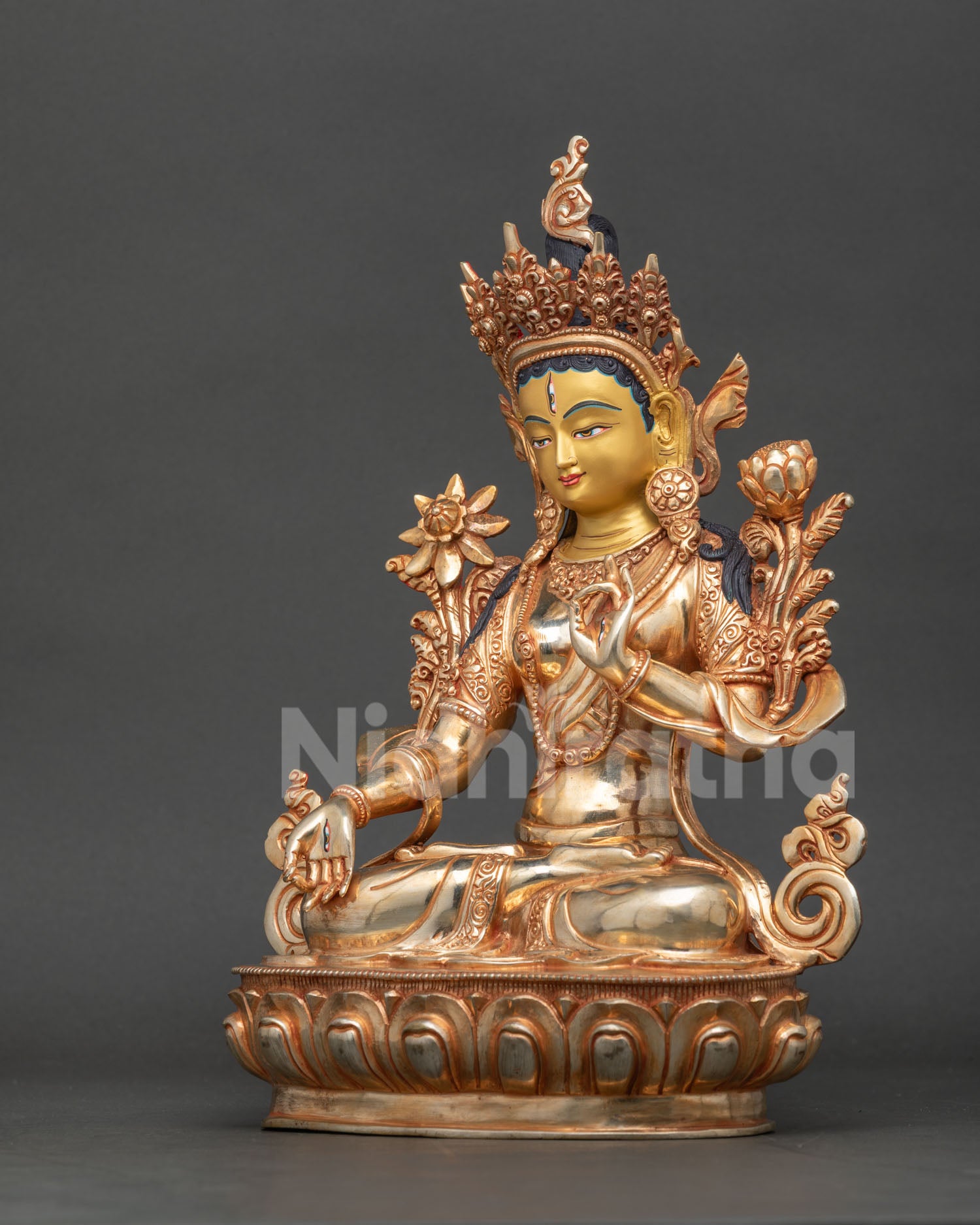 White Tara statue seated on lotus pedestal with seven eyes on face palms and soles symbolizing compassion.