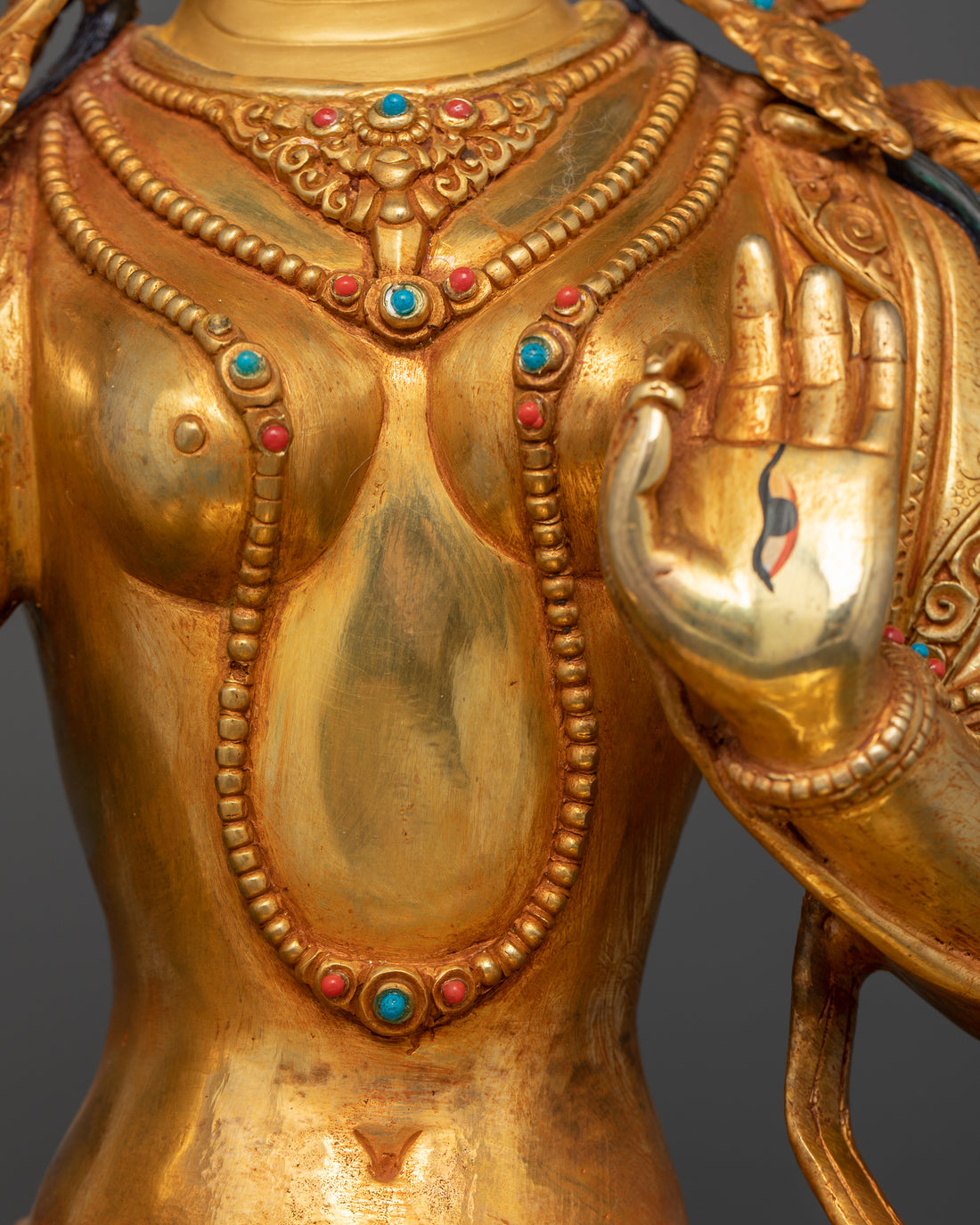 torso of white tara statue with necklace adorned with gemstones