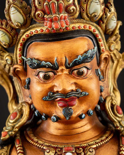 Yellow Dzambhala face close-up with wrathful expression and jeweled crown