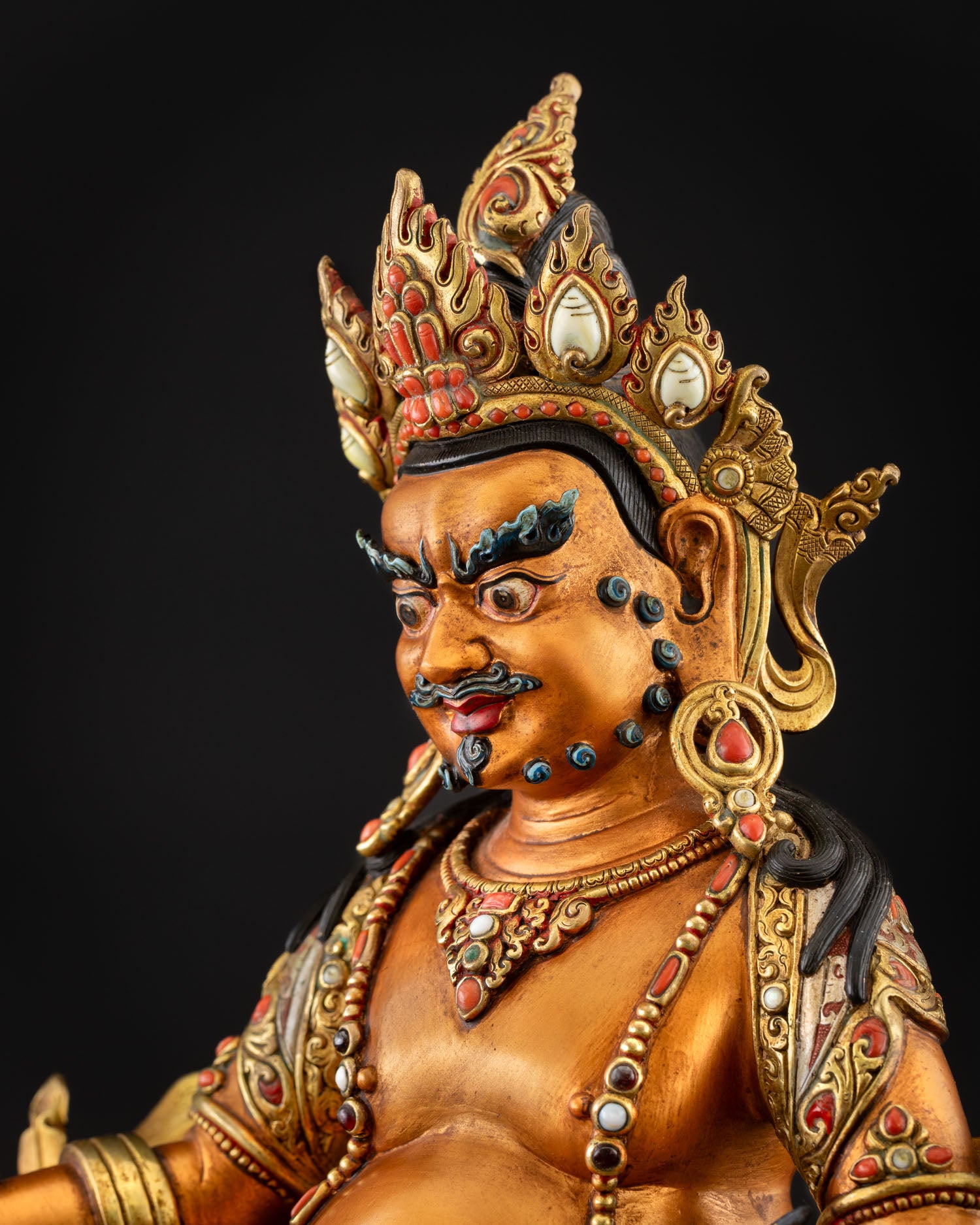 Yellow Dzambhala statue side profile with ornate crown details