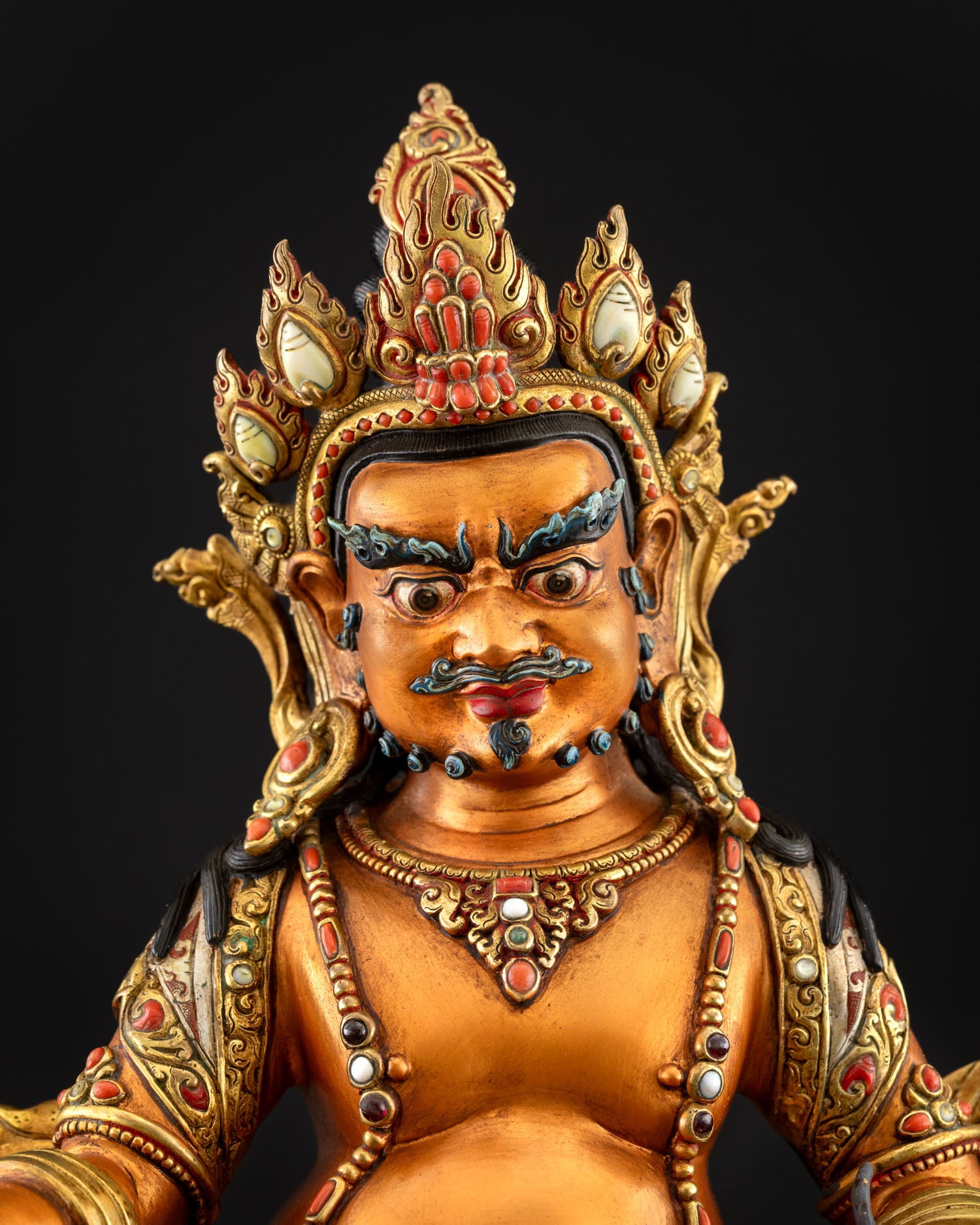 Yellow Dzambhala statue upper body close-up showing crown and jewelry